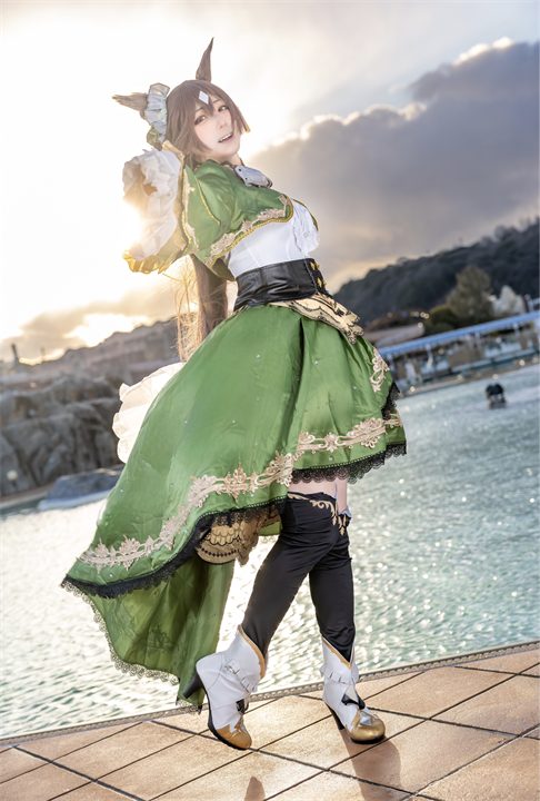 夕空を背景に、緑のドレスとブーツで立つぷらる