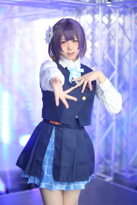 紫の光の中で、紺色の衣装を着たぷらる